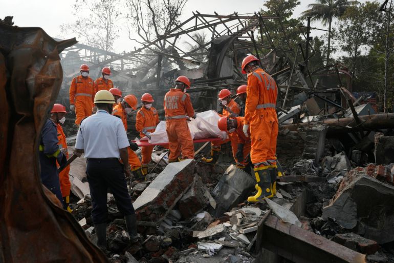 National Disaster Response Force rescuers carry the dead body of a person after an explosion and fire at a chemical factory in Dombivali near Mumbai, India