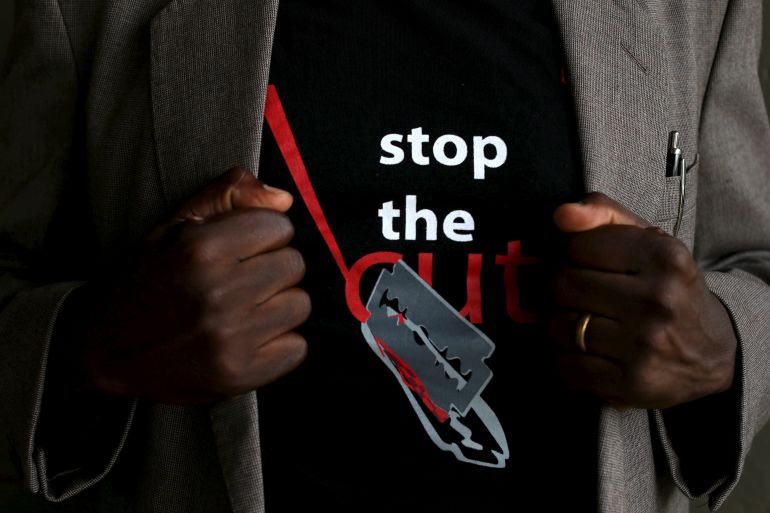 A man shows the logo of a T-shirt that reads "Stop the Cut" referring to Female Genital Mutilation (FGM) during a social event advocating against harmful practices such as FGM at the Imbirikani Girls High School in Imbirikani, Kenya