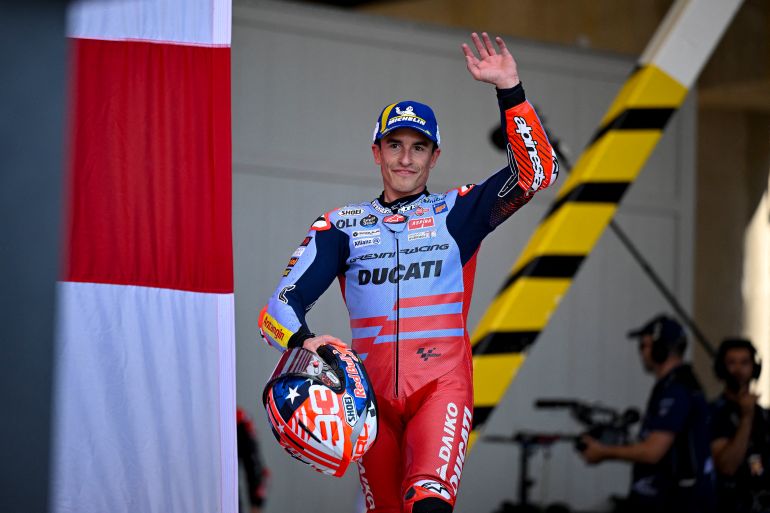 Motorcycle racer waves to crowd.