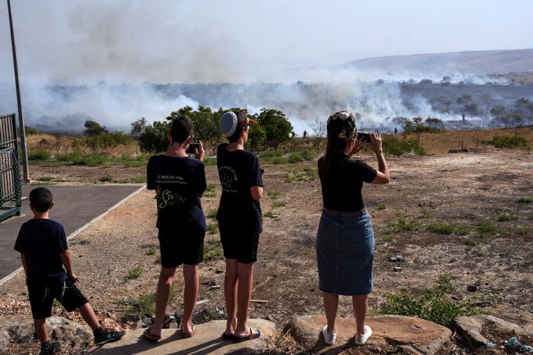 Israelis look at smoke and fire following over border attacks from Lebanon, amid ongoing cross-border hostilities between Hezbollah and Israeli forces, in Katzrin in the Israeli-occupied Golan Heights, June 13, 2024. REUTERS/Ayal Margolin ISRAEL OUT. NO COMMERCIAL OR EDITORIAL SALES IN ISRAEL