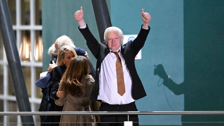 WikiLeaks founder Julian Assange gestures at supporters after arriving at Canberra Airport