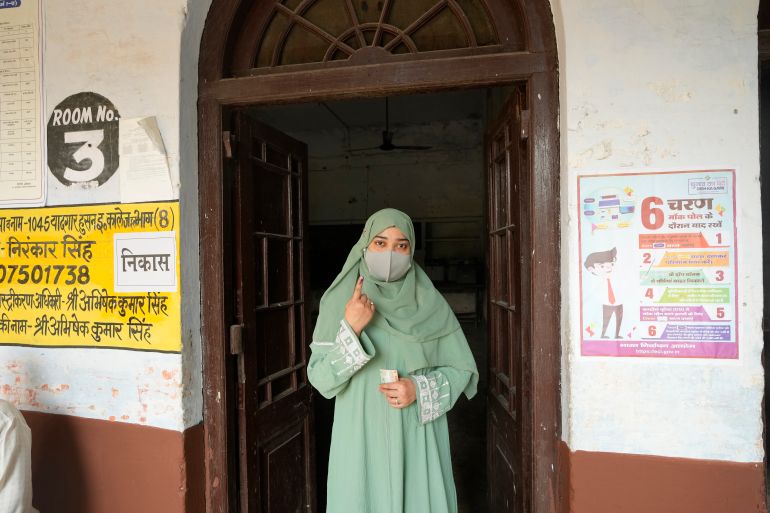 A Muslim voter shows her index finger marked with an indelible ink after casting her vote