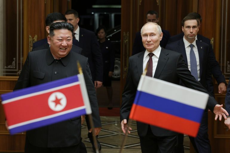 Putin and Kim. They are behind the flags of their countries and smiling