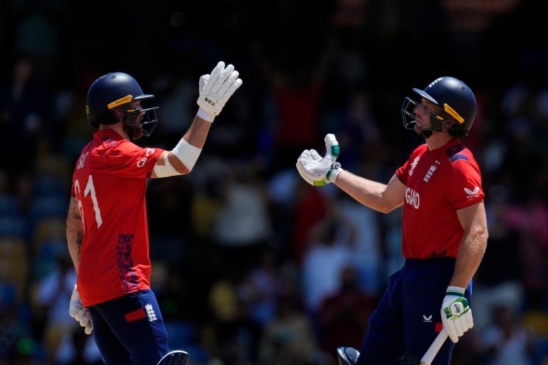England's captain Jos Buttler, left, and batting partner Phil Salt celebrate after their win in the ICC Men's T20 World Cup cricket match between the United States and England at Kensington Oval in Bridgetown, Barbados, Sunday, June 23, 2024. (AP Photo/Ricardo Mazalan)