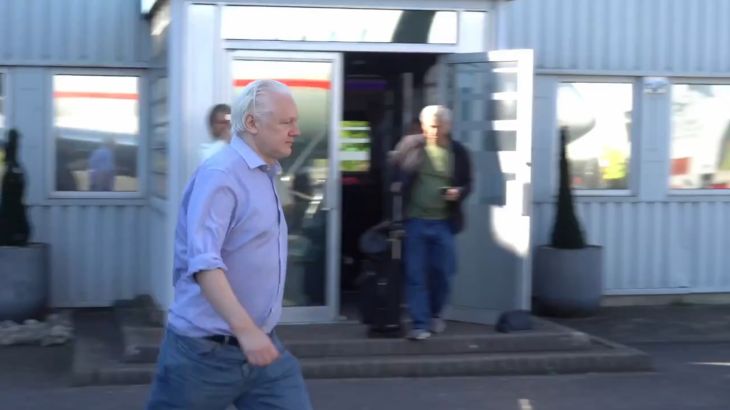 Julian Assange walking on tarmac at UK airport