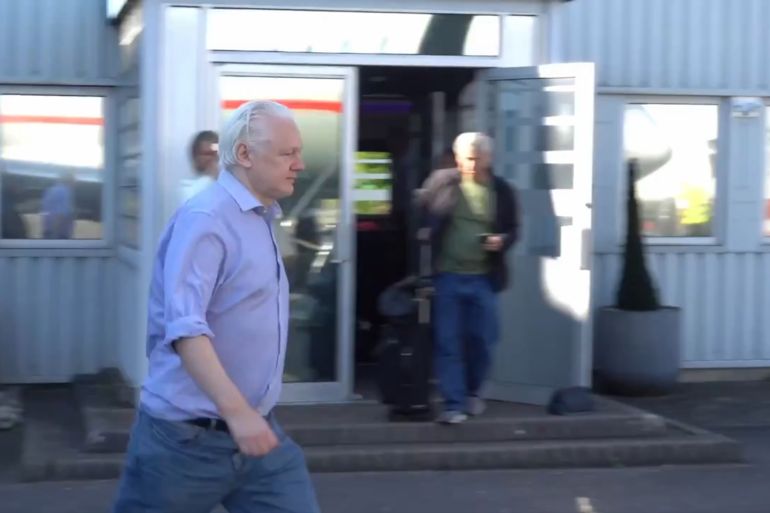 Julian Assange walking on tarmac at UK airport