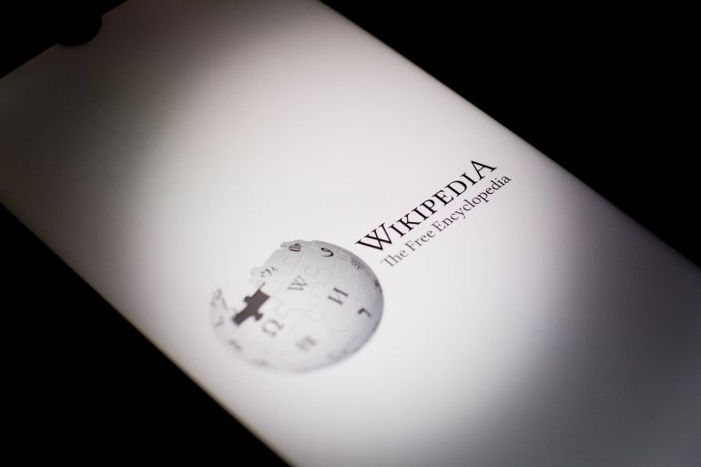 The Wikipedia logo is being displayed on a smartphone screen in Athens, Greece