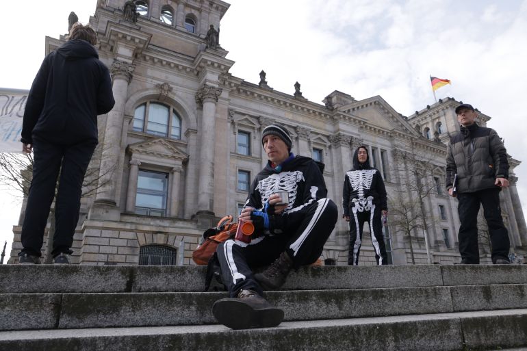 BERLIN, GERMANY - APRIL 04: Wolfgang Metzeler-Kick (C), an environmental engineer, takes a break as he and Richard Cluse (R), an energy engineer, who are both on a hunger strike, join "Last Generation" activists in a small protest demonstration in Berlin's government quarter next to the Reichstag on April 04, 2024 in Berlin, Germany. The two men have been camped out near the Chancellery and on a hunger strike since March ander the motto: "To Hunger Until You're Honest!" ("Hungern Bis Ihr Ehrlich Seid!") in a direct demand directed at German Chancellor Olaf Scholz and his government to take stronger measures towards mitigating climate change. Members of the climate activists group "Scientist Rebellion" have announced their intent to join the hunger strike in coming days. (Photo by Sean Gallup/Getty Images)