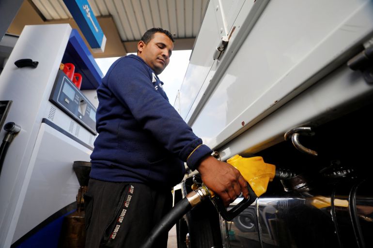 A worker fills a car's tank in Cairo, Egypt