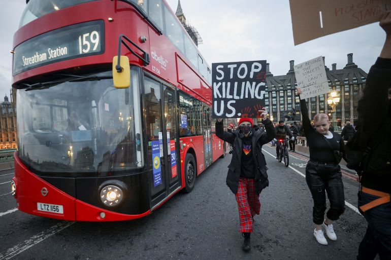 Women hold signs during a protest at Westminster Bridge, following the kidnap and murder of Sarah Everard, in London, Britain March 15, 2021. REUTERS/Hannah McKay