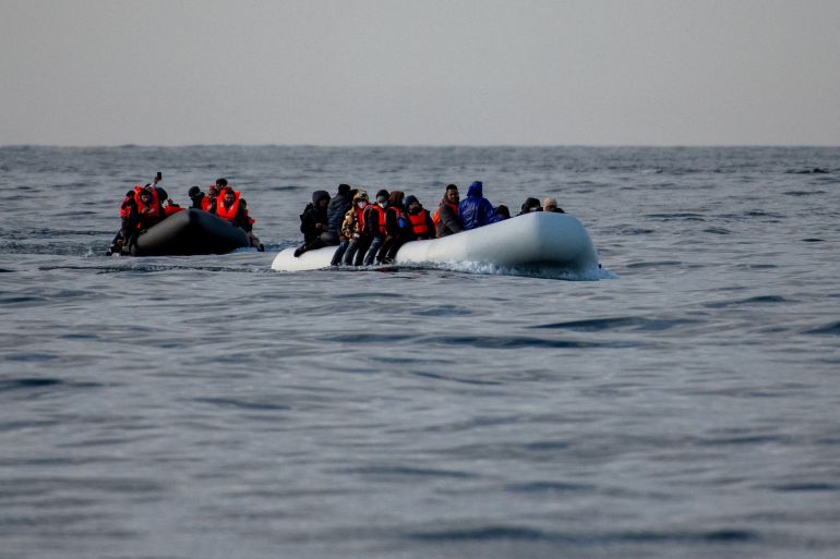 Two inflatable dinghies carrying migrants make their way towards England in the English Channel,