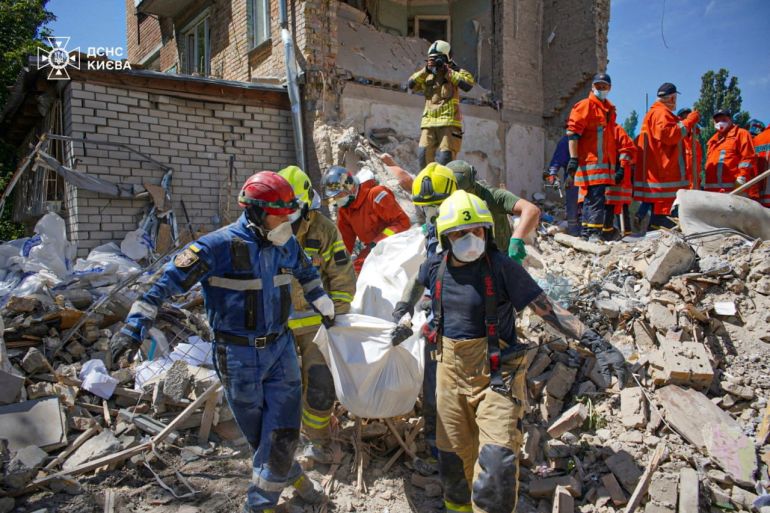 Rescuers carry the body of a person found under debris at the site where an apartment building was hit by a Russian missile strike, amid Russia's attack on Ukraine, in Kyiv, Ukraine July 9, 2024.