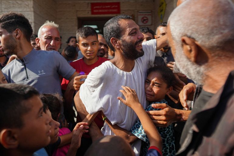 A Palestinian man who had been detained by Israeli forces is welcomed by family and well-wishers as he arrives after his release for a check-up at the Al-Aqsa Martyrs Hospital in Deir al-Balah in the central Gaza Strip on July 1, 2024 amid the ongoing conflict between Israel and the Palestinian Hamas movement. (Photo by Bashar TALEB / AFP)