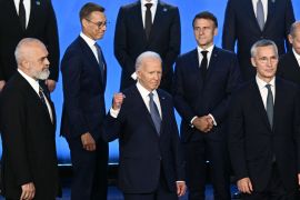 US President Joe Biden gestures as the NATO heads of state pose for a family photo during the NATO 75th anniversary summit at the Walter E Washington Convention Center in Washington, DC, on July 10, 2024 [Brendan Smialowski/AFP]