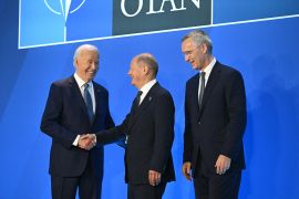 German Chancellor Olaf Scholz, centre, is welcomed by US President Joe Biden, left, and NATO Secretary-General Jens Stoltenberg at the NATO summit in Washington, DC, on July 10 [Saul Loeb/AFP]