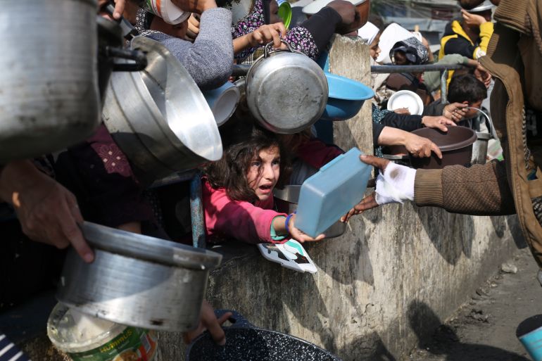 FILE - Palestinians line up for free food during the ongoing Israeli air and ground offensive on the Gaza Strip in Rafah, Jan. 9, 2024. A top U.N. official said Friday, May 3, 2024, that hard-hit northern Gaza was now in “full-blown famine" after more than six months of war between Israel and Hamas and severe Israeli restrictions on food deliveries to the Palestinian territory. (AP Photo/Hatem Ali, File)