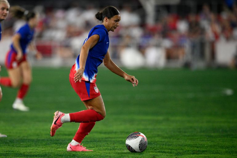 Football player dribbling ball during game.