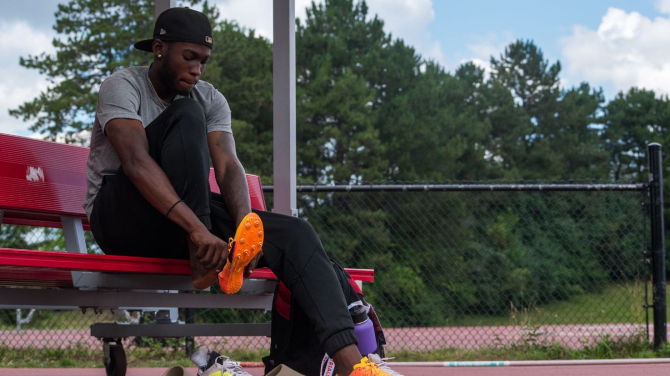 Tamarri Lindo laces up his cleats at a Toronto track