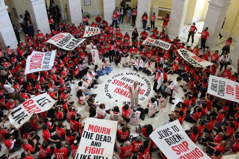 Activists wearing red displaying banners that call for stepping weapons to Israel