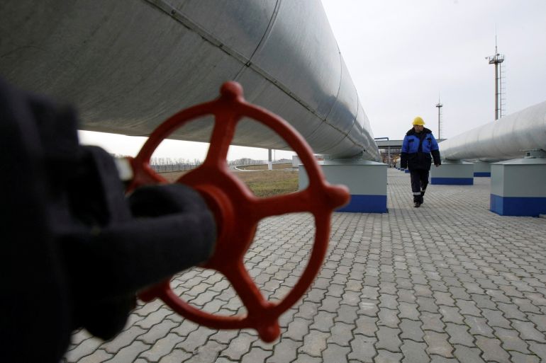 A Gazprom worker walks next to pipelines at a gas measuring station at the Russian-Ukrainian border in Sudzha