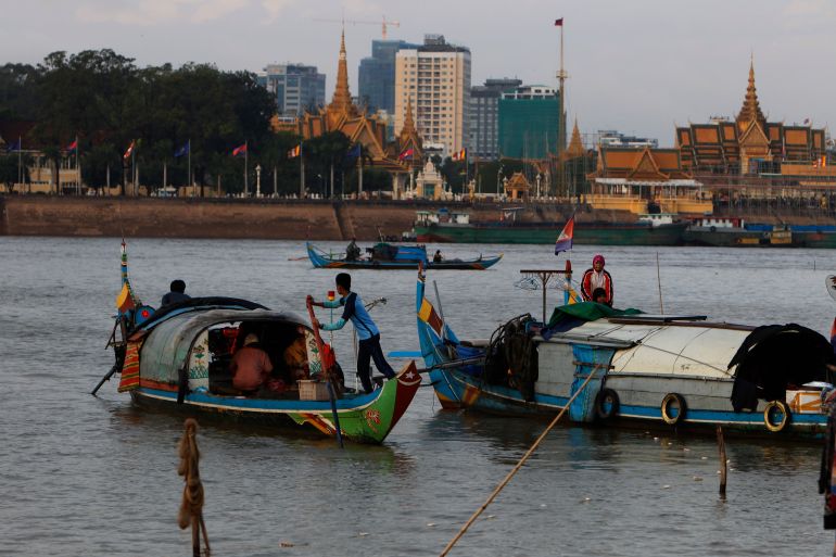 Fishermen row their wooden boats at a conjunction of rivers between the Mekong river and Tonle Sap as they catch fish during the fish harvesting season near Phnom Penh, Cambodia, Wednesday, Nov. 28, 2018. (AP Photo/Heng Sinith)