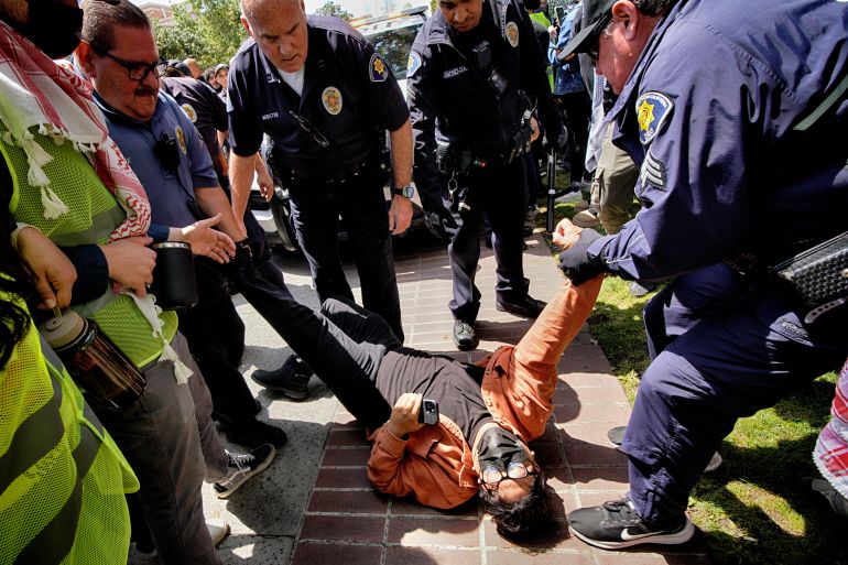 FILE - A University of Southern California protester is detained by USC Department of Public Safety officers during a pro-Palestinian occupation at the campus' Alumni Park, April 24, 2024, in Los Angeles. (AP Photo/Richard Vogel, File)