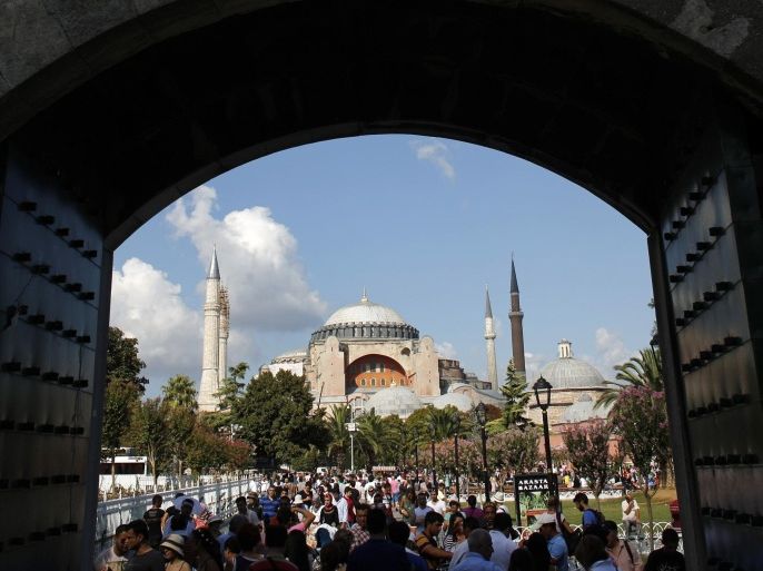 Local and foreign visitors, with the Byzantine-era monument of Hagia Sophia in the background, stroll at Sultanahmet square in Istanbul August 23, 2013. The number of foreign visitors arriving in Turkey grew at its slowest pace for eight months in July, as the impact of anti-government protests and the Muslim fasting month of Ramadan took their toll, data showed on Friday. Foreign arrivals rose 0.48 percent year-on-year last month to 4.59 million people, according to the Tourism Ministry figures, the lowest rise since November. The number of visitors rose 4.93 percent the previous month. REUTERS/Murad Sezer (TURKEY - Tags: POLITICS TRAVEL)
