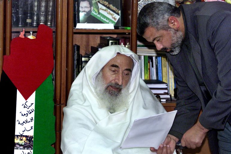 FILE PHOTO: Sheikh Ahmed Yassin, Hamas's founder and spiritual leader reads a paper put forward to him by Ismail Haniyeh at his house in the Gaza Strip February 27, 2002. REUTERS/Suhaib Salem/File Photo