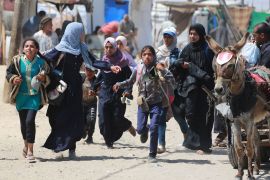 فلسطينيون يهرولون أثناء قصف إسرائيلي لمنطقة رفح في جنوب قطاع غزة (الفرنسية)