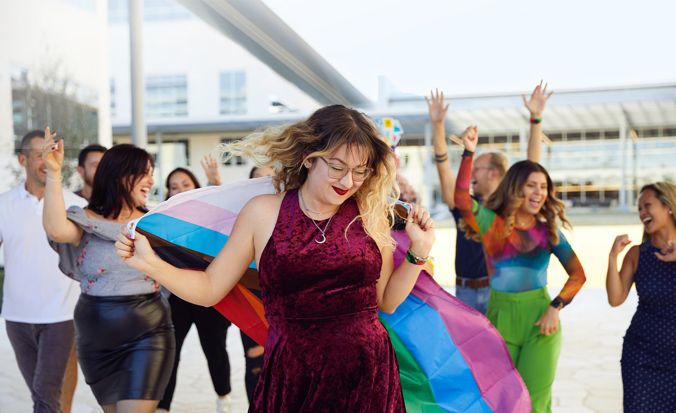 Un grupo de empleados de Apple bailando y pasándolo bien al aire libre.