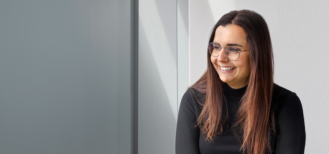 Federica sentada em um ambiente interno. Ela está sorrindo.