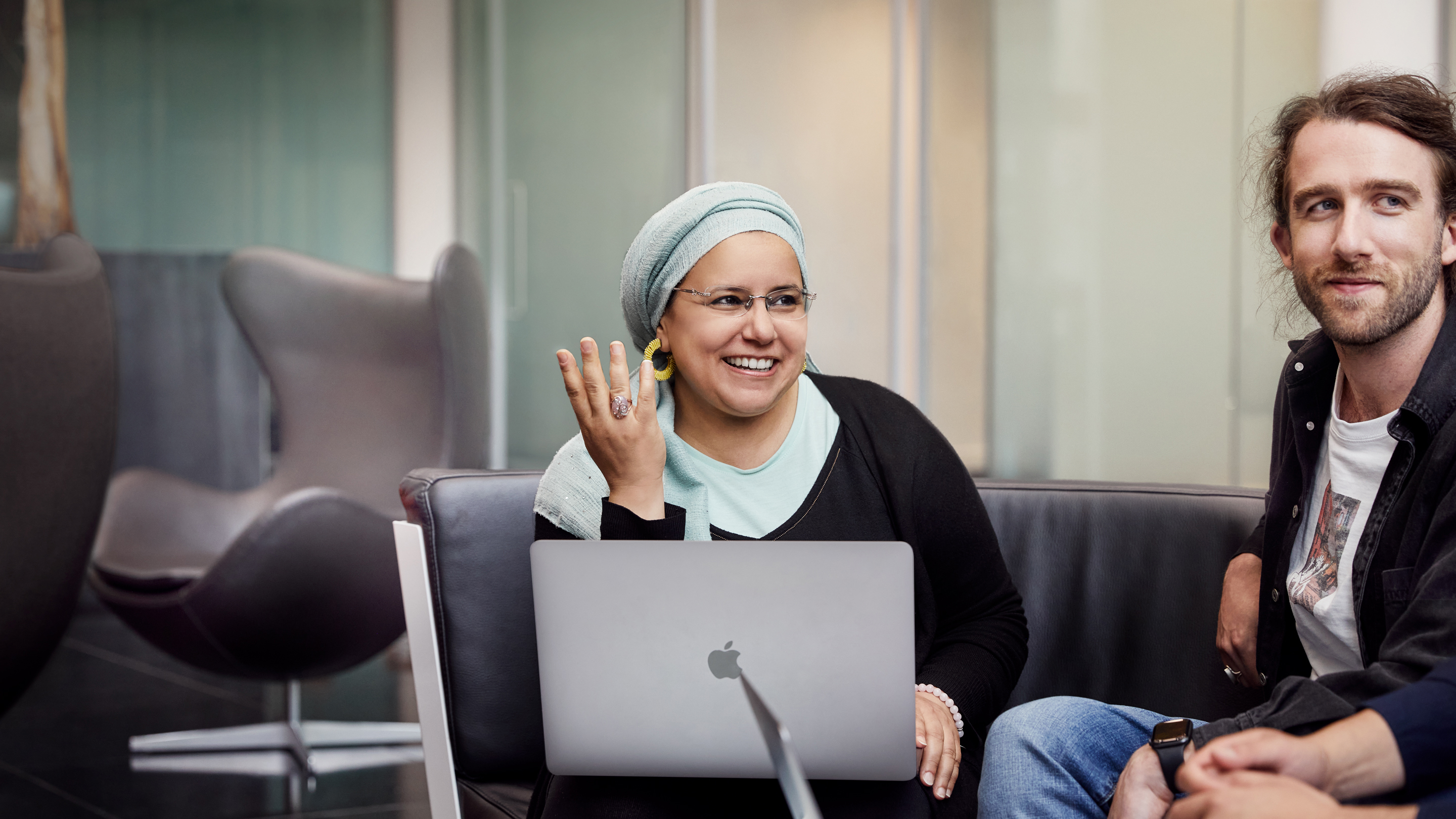 Egymás mellett ülő, együtt dolgozó Apple Cork-alkalmazottak.