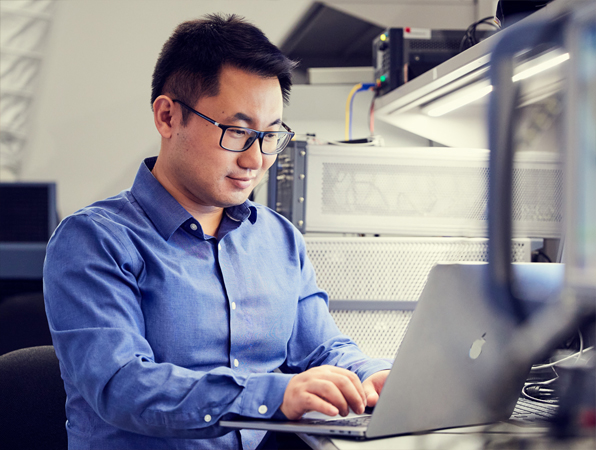 Apple San Diego Hardware employee working on his laptop in a lab.