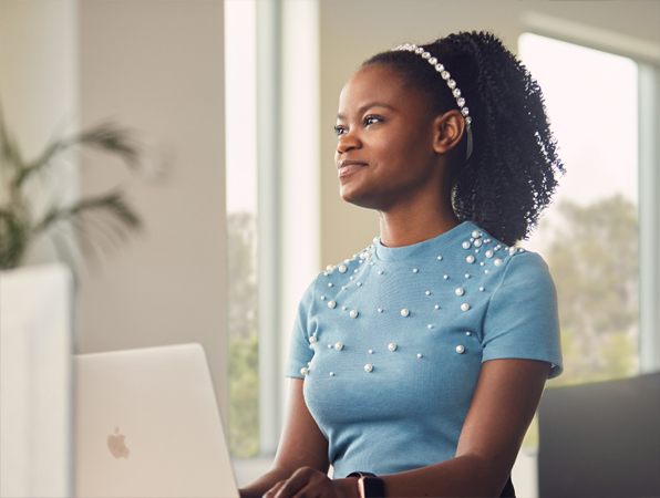 Funcionária da equipe de software e serviços da Apple San Diego trabalhando em seu laptop.