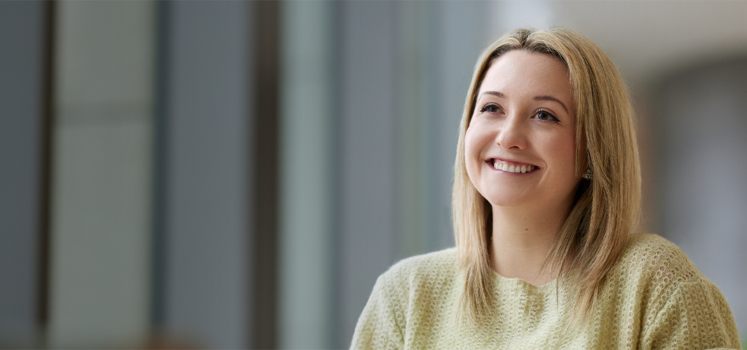 Georgia sitter og smiler med blikket vendt mot venstre.