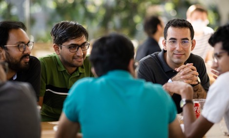  Un grupo de becarios de Apple hablando en una mesa de Caffè Macs.