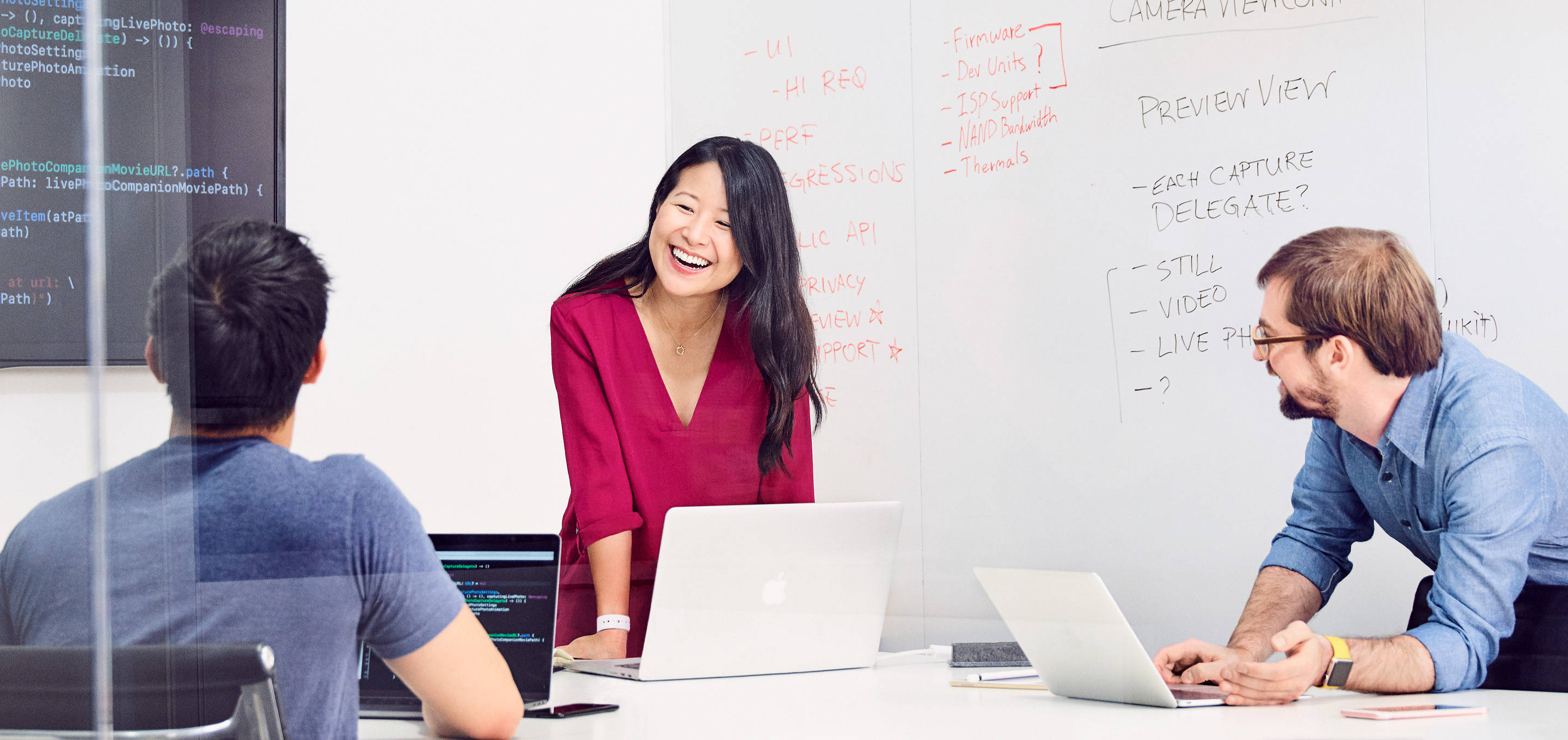 Um grupo de engenheiros de software da Apple conversa sobre um projeto em uma sala de reuniões