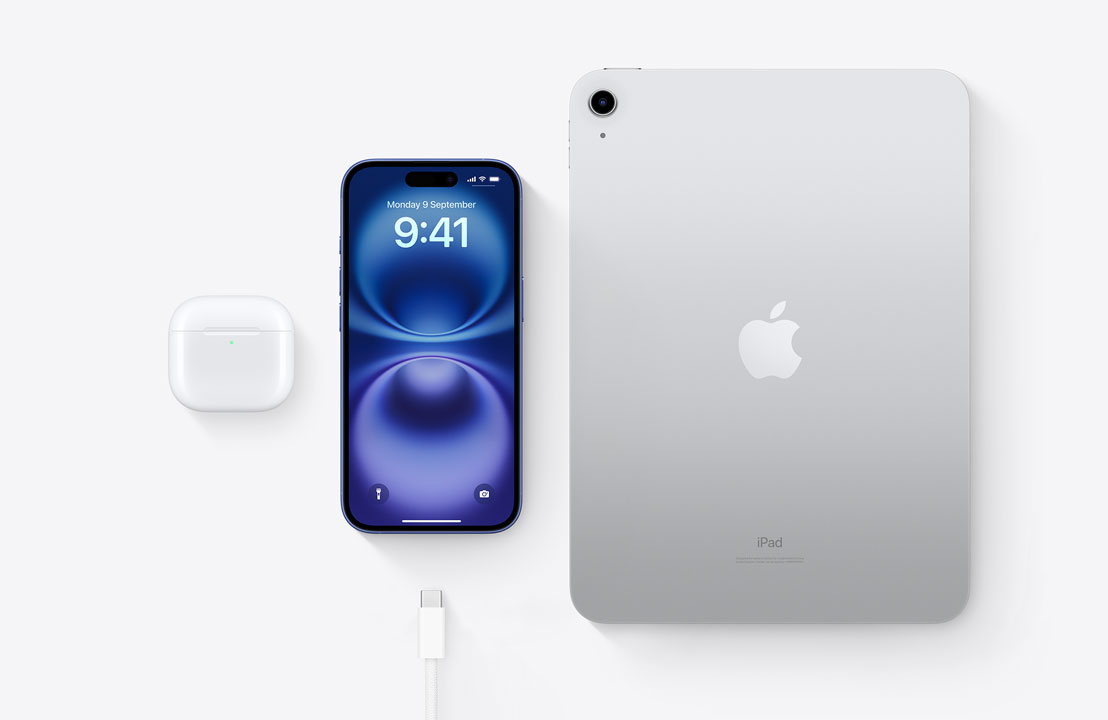 A birds-eye view of AirPods Pro, iPhone 15, and an iPad with a USB-C connector to demonstrate how all three devices can be charged using the same USB-C cable.