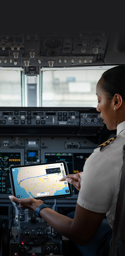 Dans un cockpit, une pilote d’avion consulte une carte sur un iPad.