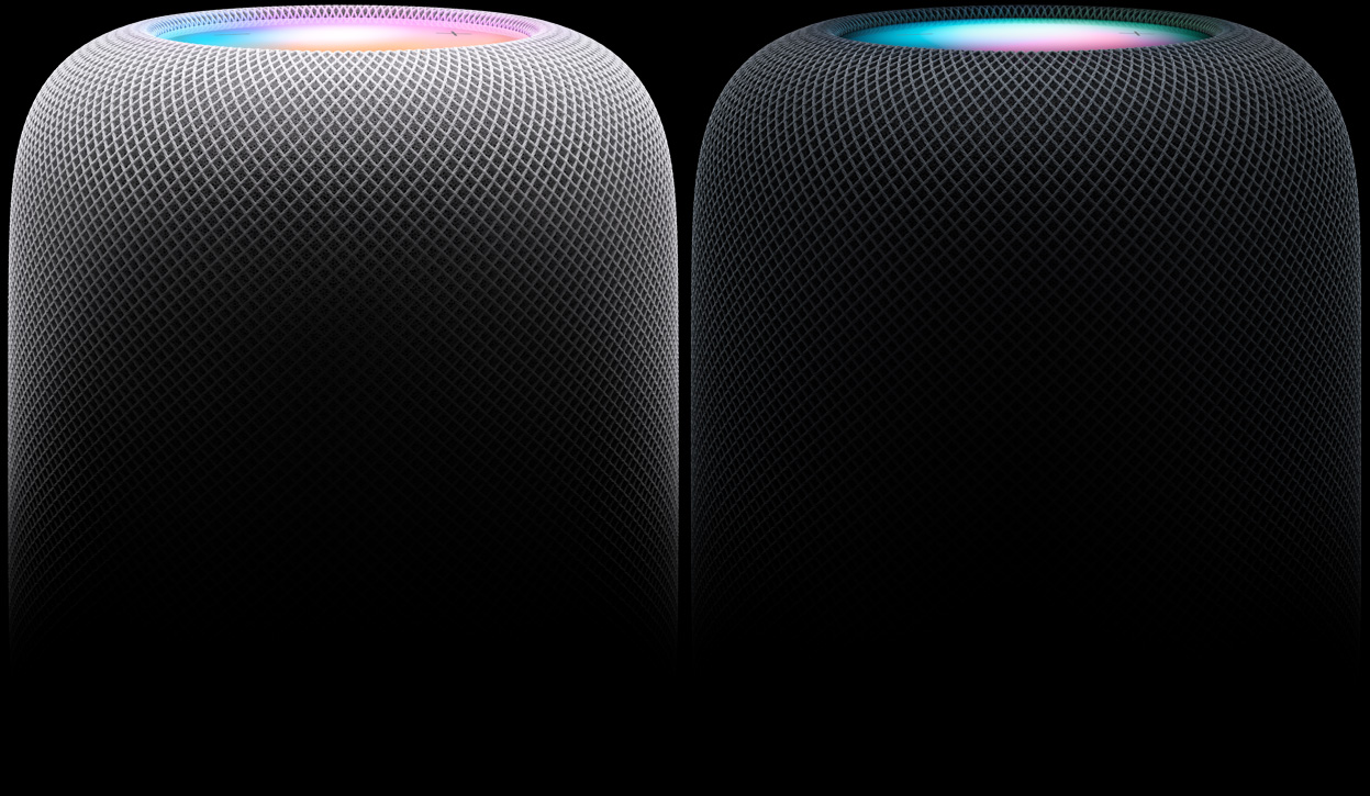 มุมมองด้านข้างของลำโพง HomePod สองตัววางอยู่ข้างกัน โดยที่ลำโพงตัวซ้ายเป็นสีขาวและลำโพงตัวขวาเป็นสีมิดไนท์