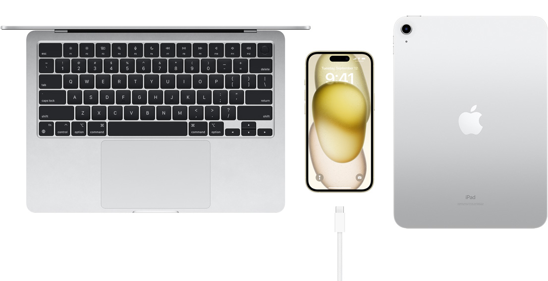 Pohled shora na MacBook Pro, iPhone 15 s USB‑C konektorem a iPadem