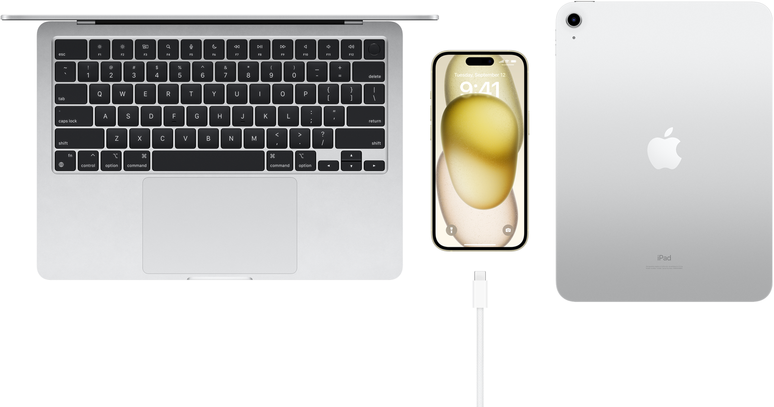 Felülnézetből mutatott MacBook Pro, iPhone 15 USB-C kábellel és iPad