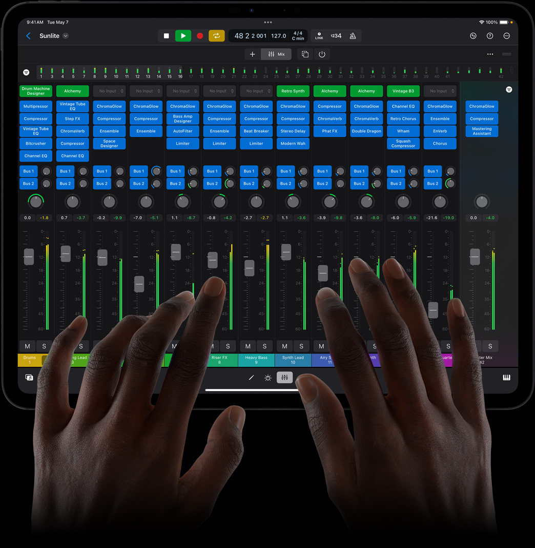 Duas mãos tocam o iPad Pro e usam um console de mixagem completo no Logic Pro para iPad.