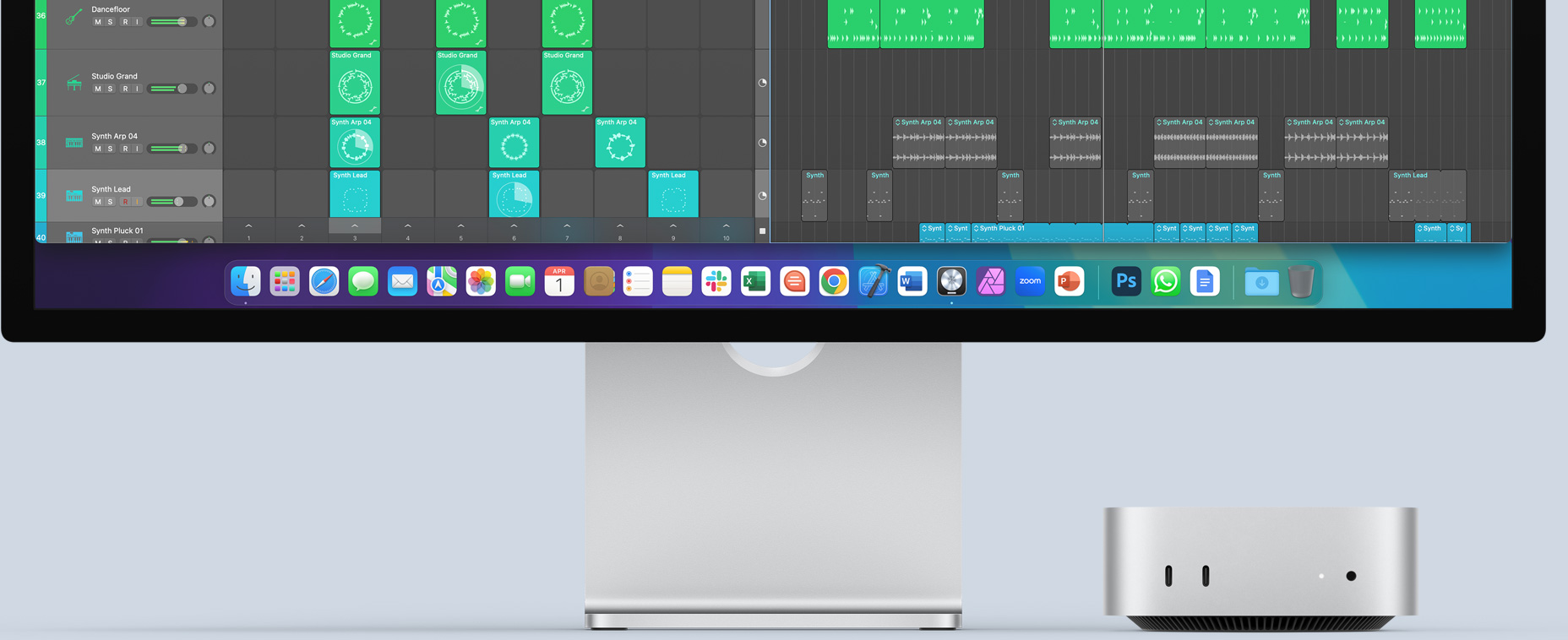 Vista frontal de una Mac mini con puertos delanteros y luz de encendido, que encaja perfectamente debajo de un monitor Mac con una pantalla colorida e íconos de apps en el Dock