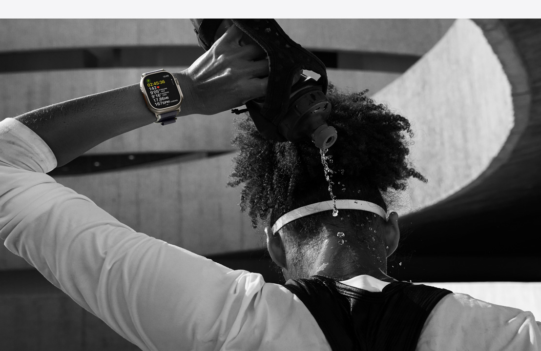 Sportaš se polijeva vodom po vratu dok nosi Apple Watch Ultra 2.