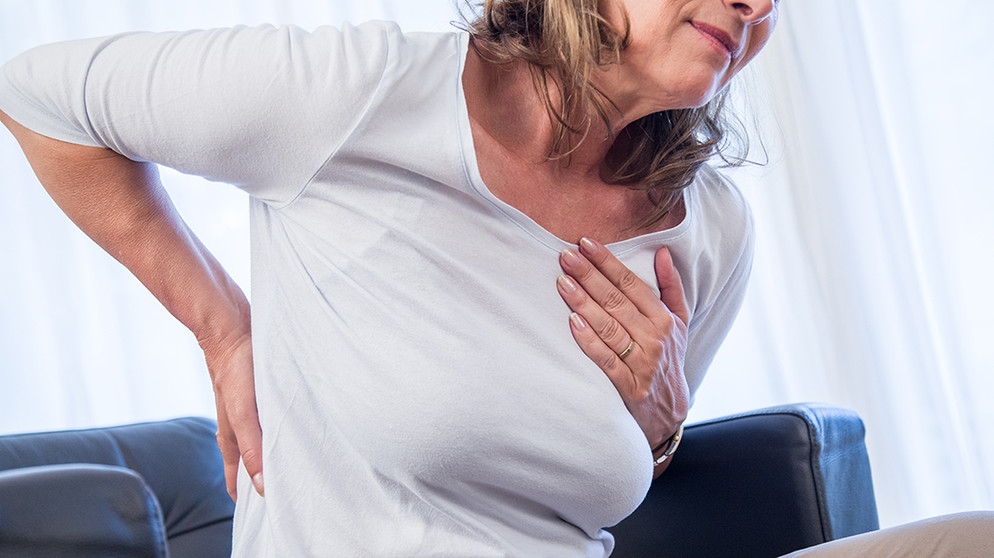 Eine Frau fasst sich im Schmerz an Brust und Rücken. In der Medizin gibt es geschlechtsspezifische Unterschiede, das gilt für Krankheiten sowie Symptome. Fehldiagnosen können die Folgen sein. Beim Herzinfarkt ist das lebensgefährlich. | Bild: picture alliance/dpa Themendienst | Christin Klose