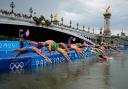 Athletes dive into the water for the start of the women’s individual triathlon (AP)