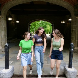 3 students walking through the friendship poles