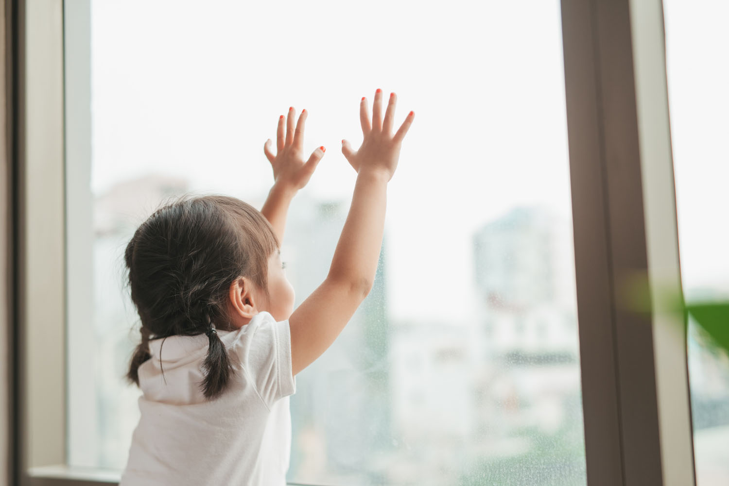 Young girl looking out window