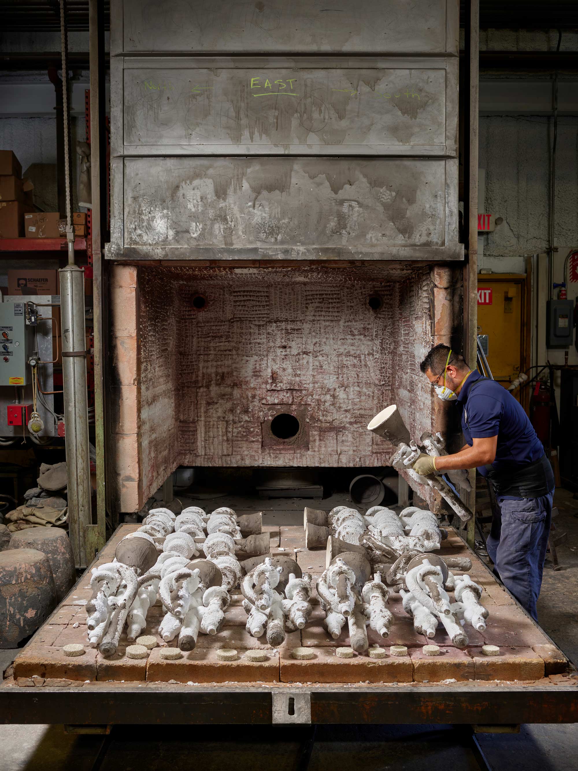 The ceramic shells with the wax figures are put into a kiln to heat up. The wax melts out, creating a hollow vessel.